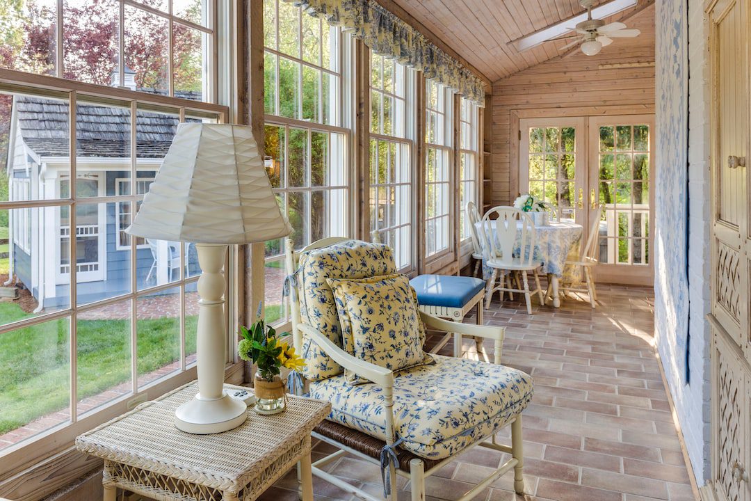 Converted porch filled with windows and furniture